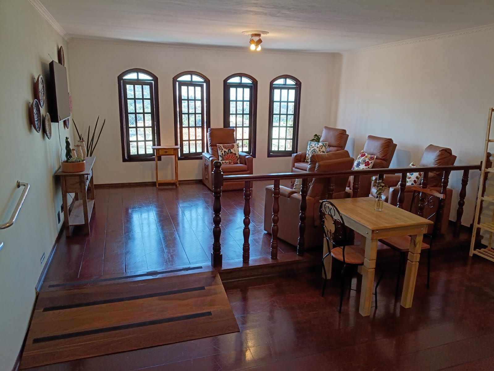 Sala de convivência ampla com poltronas e iluminação natural