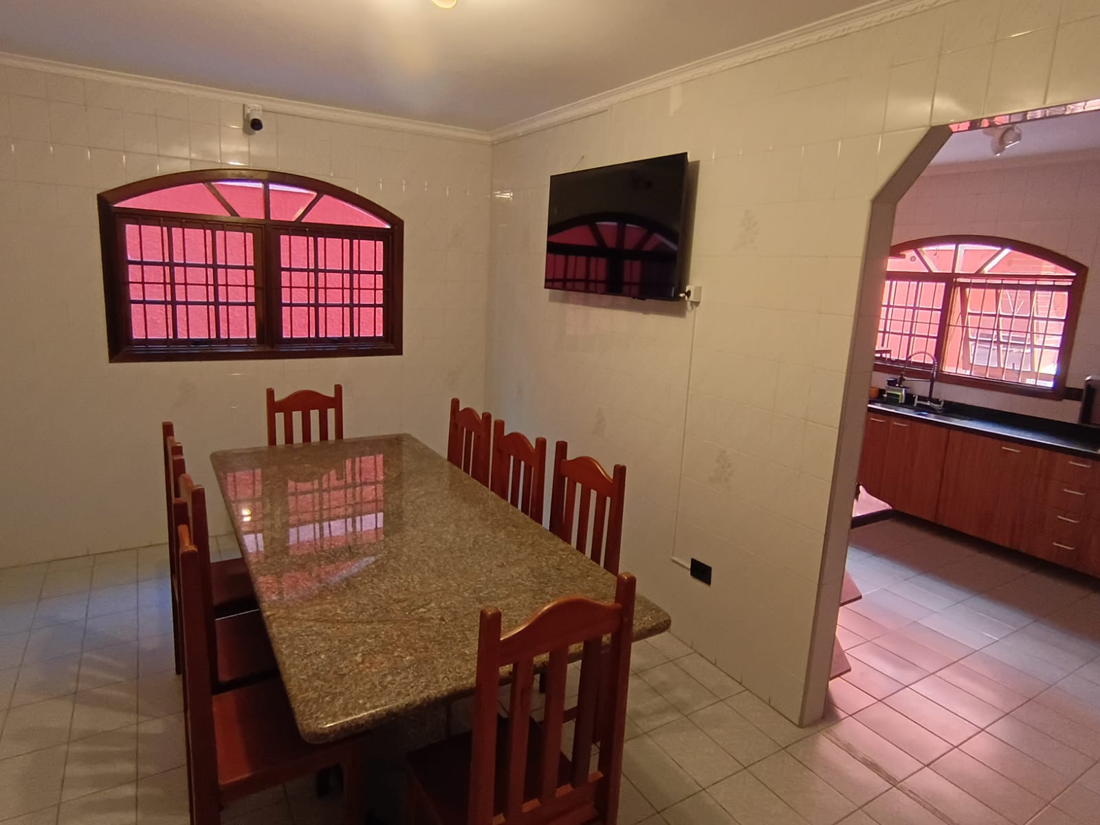 Refeitório da GERAS com mesa ampla e acesso à cozinha